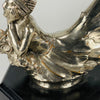 Wave rider Car bonnet mascot by Georges Delperier  in the form of a winged woman laying on her front in a casual pose riding on top of a wave, with very fine hand finished detail. Raised on an octagonal wooden plinth