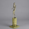 Art Deco Lady by Adolph in a questioning pose with one hand out, signed Adolph and raised on a tall cylindrical Brazilian green onyx base