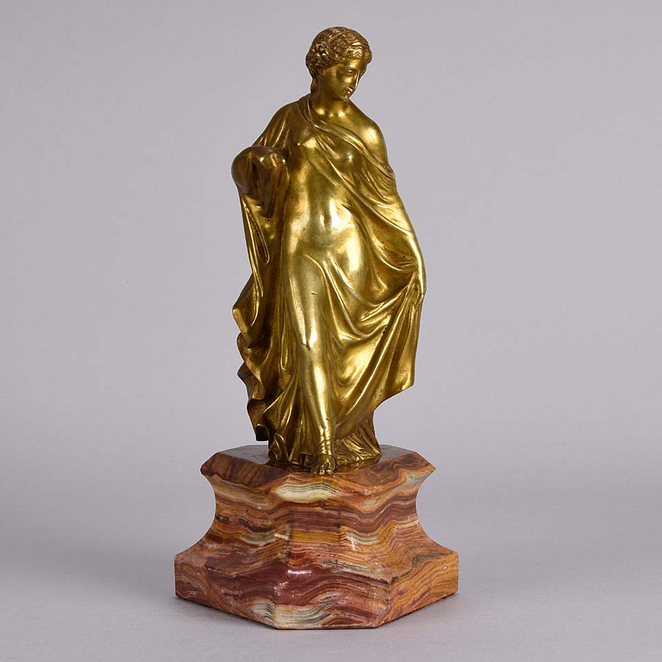 An antique bronze figure of an Art Nouveau Lady a gilt bronze figure of a very beautiful lady, her diaphonous clothing seductively draped over her body 