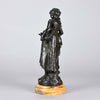Autumn an antique bronze figure by Auguste Moreau a figure of a young farm girl carrying a laden basket with very fine colour and excellent had finished surface detail, raised on a marble base 