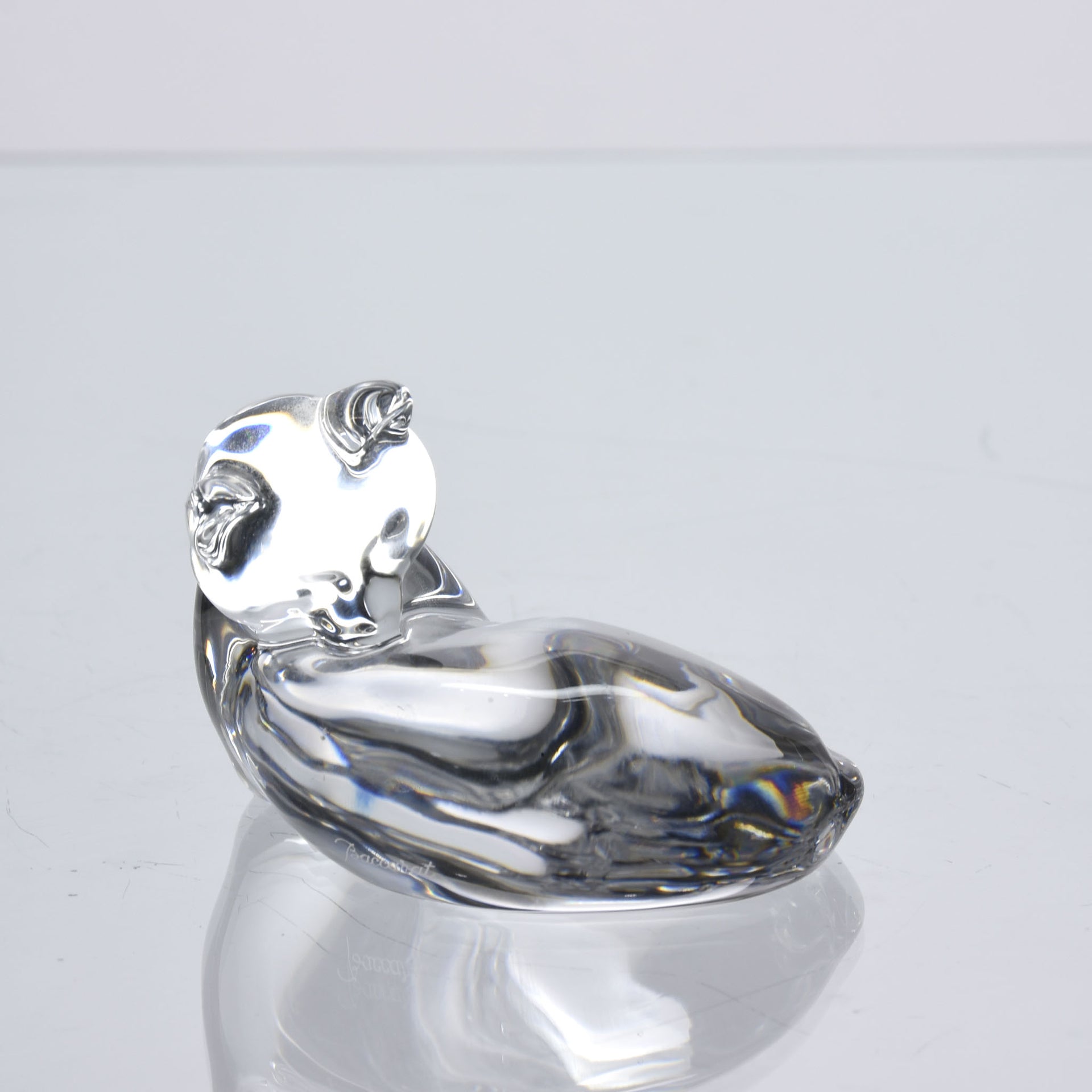 A charming mid 20th Century clear glass study of a relaxed cat in a reclining position grooming itself, with excellent smooth tactile surface, signed under base 