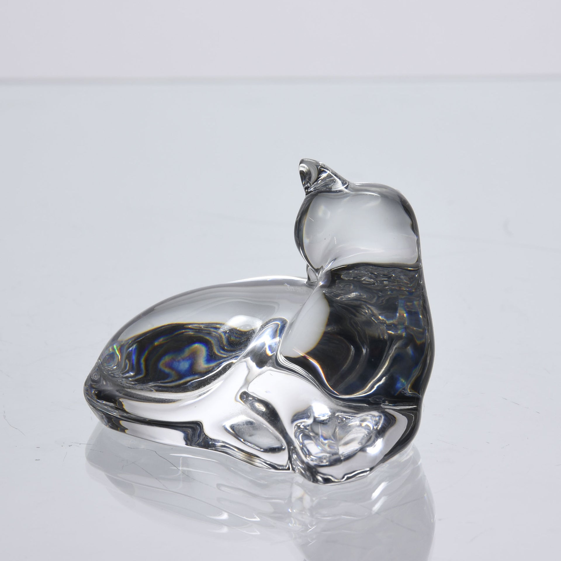 A charming mid 20th Century clear glass study of a relaxed cat in a reclining position grooming itself, with excellent smooth tactile surface, signed under base 