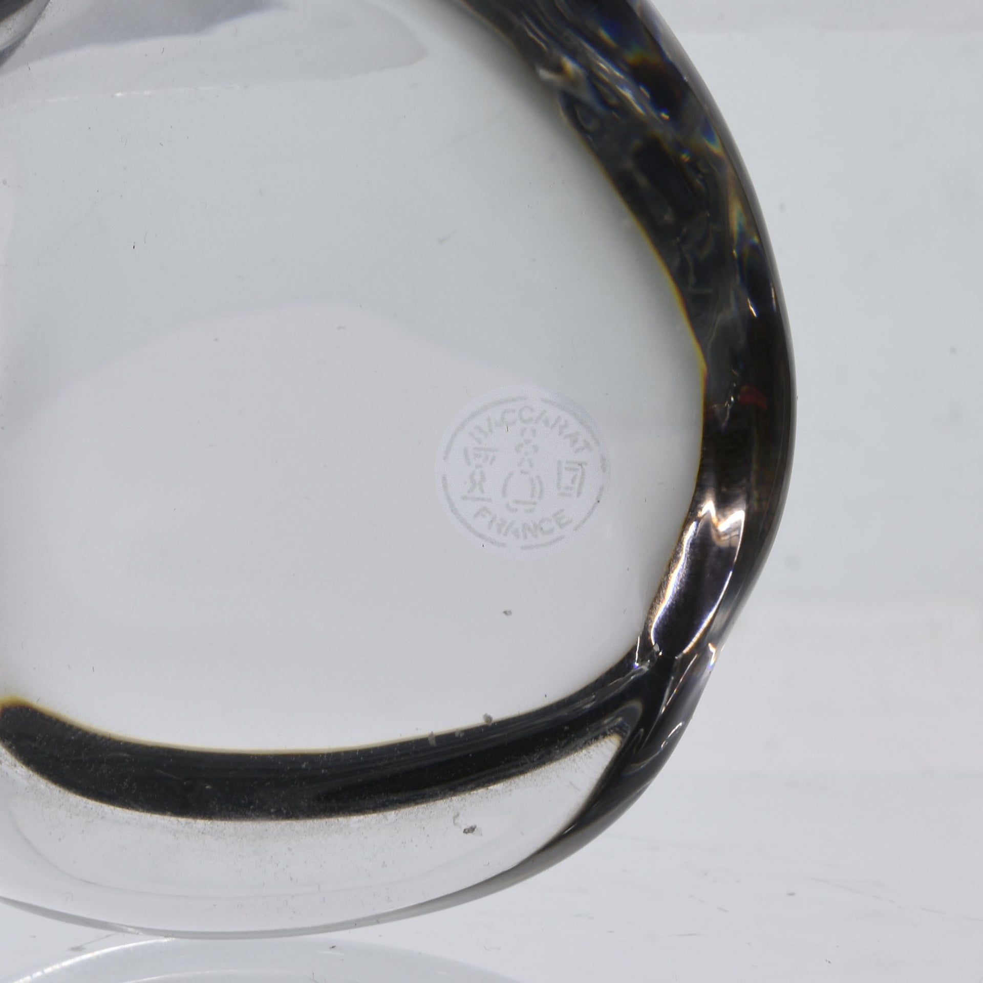 A charming mid 20th Century clear glass study of a relaxed cat in a reclining position grooming itself, with excellent smooth tactile surface, signed under base 