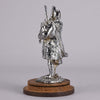 Bagpipes Car Bonet Mascot in the form of a Scotsman dressed in a kilt playing the bagpipes. Exhibiting a well polished surface and fine hand finished detail it is raised and fitted on a stepped circular stand