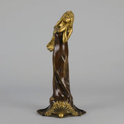 Jeune Femme by C Peyre A very fine Art Nouveau bronze study of a young beauty in coy pose, clothed in a long flowing skirt, her head and arms in gilt bronze to contrast with the rich brown colour of her clothes