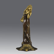Jeune Femme by C Peyre A very fine Art Nouveau bronze study of a young beauty in coy pose, clothed in a long flowing skirt, her head and arms in gilt bronze to contrast with the rich brown colour of her clothes