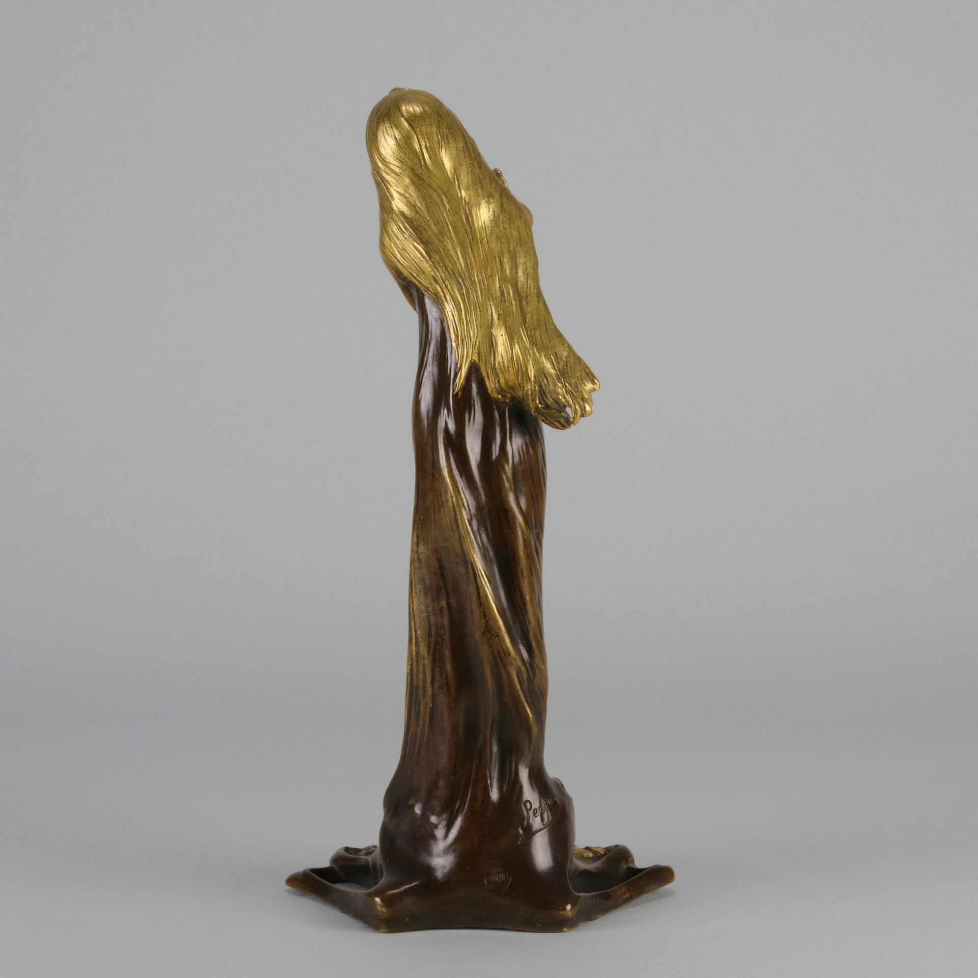Jeune Femme by C Peyre A very fine Art Nouveau bronze study of a young beauty in coy pose, clothed in a long flowing skirt, her head and arms in gilt bronze to contrast with the rich brown colour of her clothes