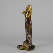 Jeune Femme by C Peyre A very fine Art Nouveau bronze study of a young beauty in coy pose, clothed in a long flowing skirt, her head and arms in gilt bronze to contrast with the rich brown colour of her clothes