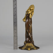 Jeune Femme by C Peyre A very fine Art Nouveau bronze study of a young beauty in coy pose, clothed in a long flowing skirt, her head and arms in gilt bronze to contrast with the rich brown colour of her clothes