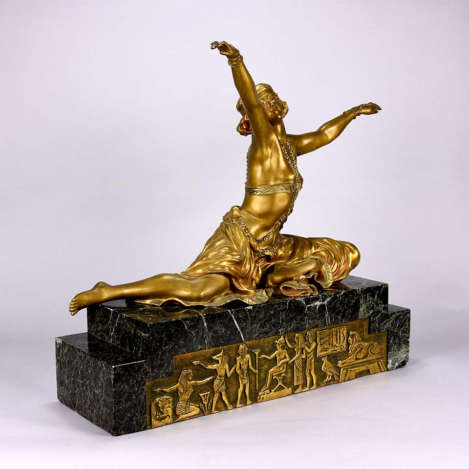 An antique bronze figure Theban Dancer by CJ R Colinet gilt and enamel bronze figure of a seated dancer wearing an exotic and revealing costume, with very fine gilt and enamel colour and excellent detail,