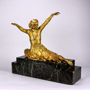 An antique bronze figure Theban Dancer by CJ R Colinet gilt and enamel bronze figure of a seated dancer wearing an exotic and revealing costume, with very fine gilt and enamel colour and excellent detail,