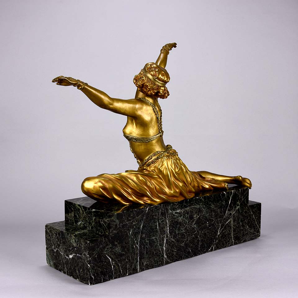 An antique bronze figure Theban Dancer by CJ R Colinet gilt and enamel bronze figure of a seated dancer wearing an exotic and revealing costume, with very fine gilt and enamel colour and excellent detail,