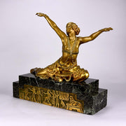 An antique bronze figure Theban Dancer by CJ R Colinet gilt and enamel bronze figure of a seated dancer wearing an exotic and revealing costume, with very fine gilt and enamel colour and excellent detail,