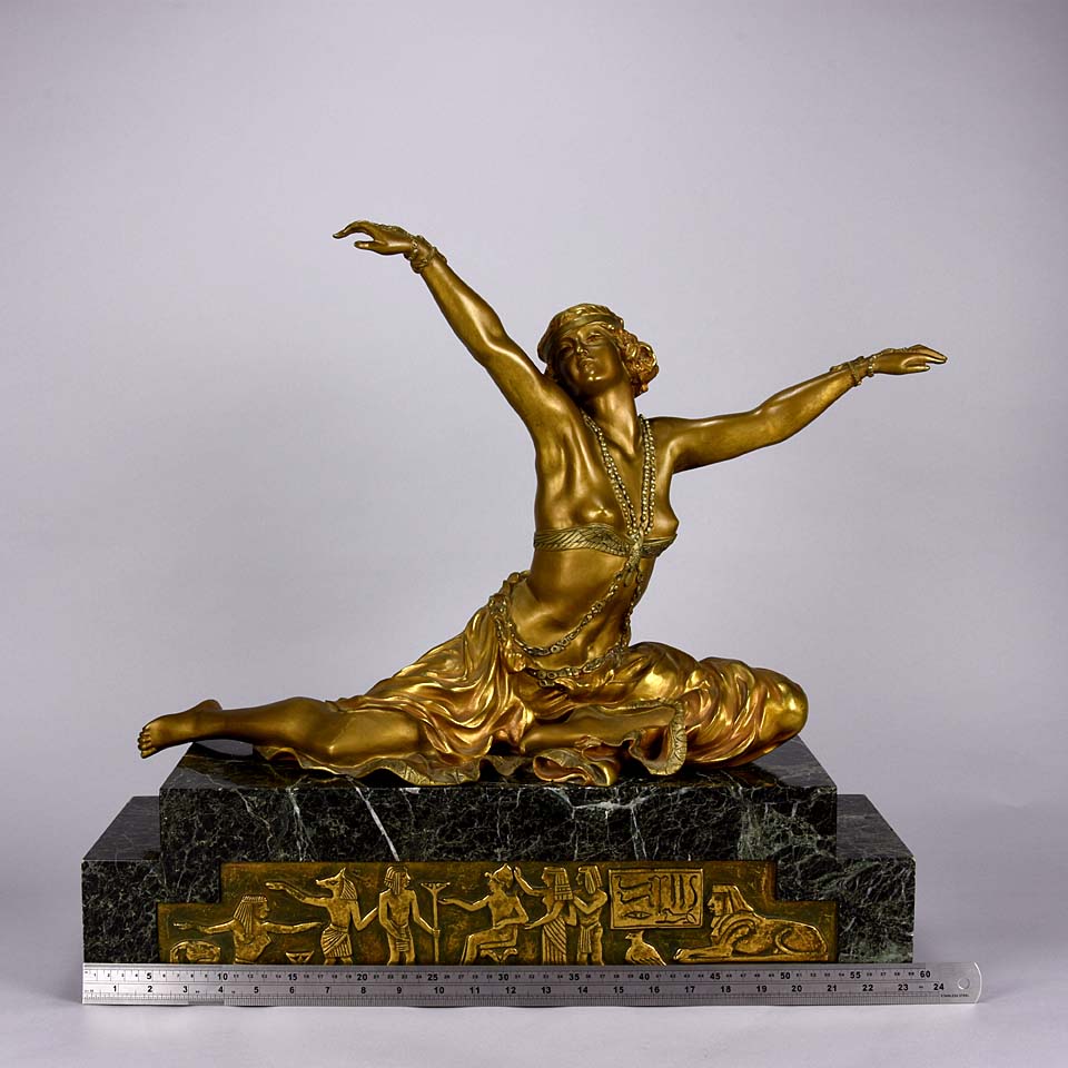 An antique bronze figure Theban Dancer by CJ R Colinet gilt and enamel bronze figure of a seated dancer wearing an exotic and revealing costume, with very fine gilt and enamel colour and excellent detail,