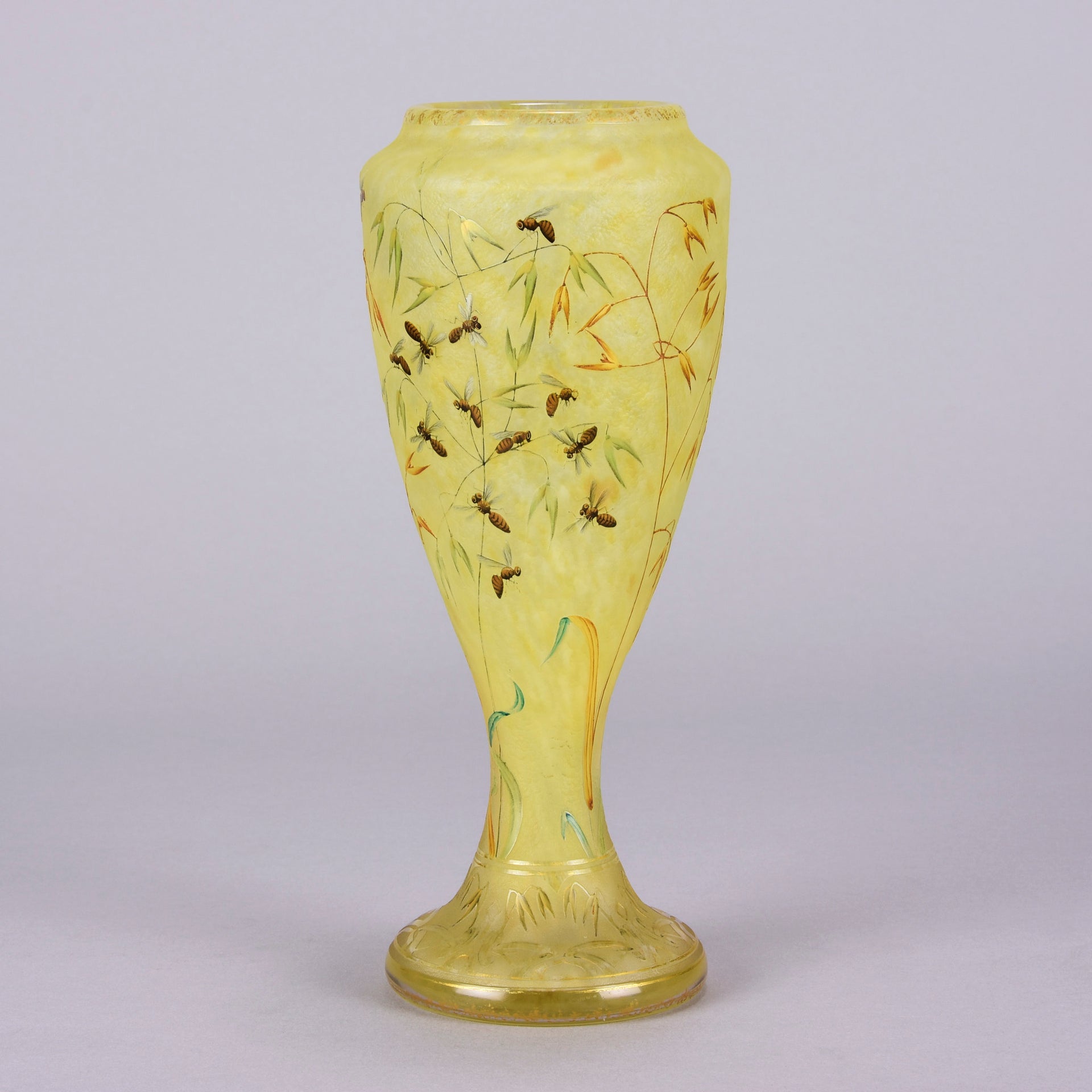 Bees and Flowers Vase by Daum Frères a late 19th Century French cameo glass vase etched and enamelled with a hive of bees pollinating flowers against a pale yellow field