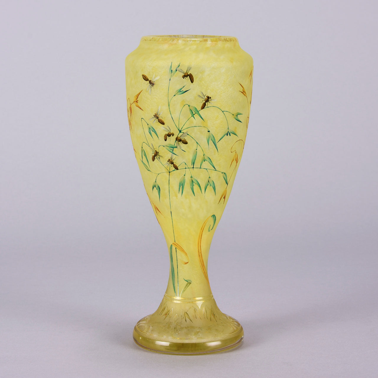Bees and Flowers Vase by Daum Frères a late 19th Century French cameo glass vase etched and enamelled with a hive of bees pollinating flowers against a pale yellow field