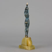  Starfish by Demetre Chiparus a  Art Deco cold painted silver and enamel bronze sculpture with ivory face and hands representing a young female Ballets Russes dancer wearing a metallic blue skin tight leotard further decorated in a bejewelled starfish pattern, modelled reaching upwards with both arms, her hands interlaced. Raised on a shaped onyx base