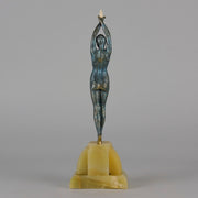  Starfish by Demetre Chiparus a  Art Deco cold painted silver and enamel bronze sculpture with ivory face and hands representing a young female Ballets Russes dancer wearing a metallic blue skin tight leotard further decorated in a bejewelled starfish pattern, modelled reaching upwards with both arms, her hands interlaced. Raised on a shaped onyx base