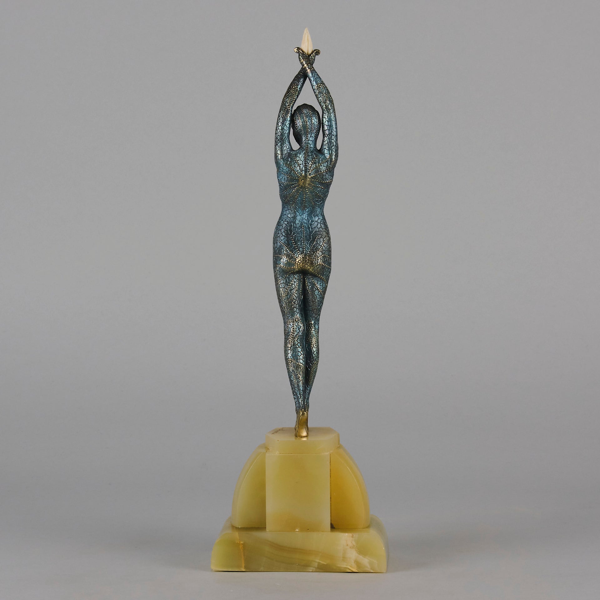  Starfish by Demetre Chiparus a  Art Deco cold painted silver and enamel bronze sculpture with ivory face and hands representing a young female Ballets Russes dancer wearing a metallic blue skin tight leotard further decorated in a bejewelled starfish pattern, modelled reaching upwards with both arms, her hands interlaced. Raised on a shaped onyx base