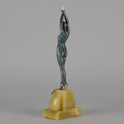  Starfish by Demetre Chiparus a  Art Deco cold painted silver and enamel bronze sculpture with ivory face and hands representing a young female Ballets Russes dancer wearing a metallic blue skin tight leotard further decorated in a bejewelled starfish pattern, modelled reaching upwards with both arms, her hands interlaced. Raised on a shaped onyx base