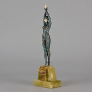  Starfish by Demetre Chiparus a  Art Deco cold painted silver and enamel bronze sculpture with ivory face and hands representing a young female Ballets Russes dancer wearing a metallic blue skin tight leotard further decorated in a bejewelled starfish pattern, modelled reaching upwards with both arms, her hands interlaced. Raised on a shaped onyx base
