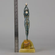  Starfish by Demetre Chiparus a  Art Deco cold painted silver and enamel bronze sculpture with ivory face and hands representing a young female Ballets Russes dancer wearing a metallic blue skin tight leotard further decorated in a bejewelled starfish pattern, modelled reaching upwards with both arms, her hands interlaced. Raised on a shaped onyx base