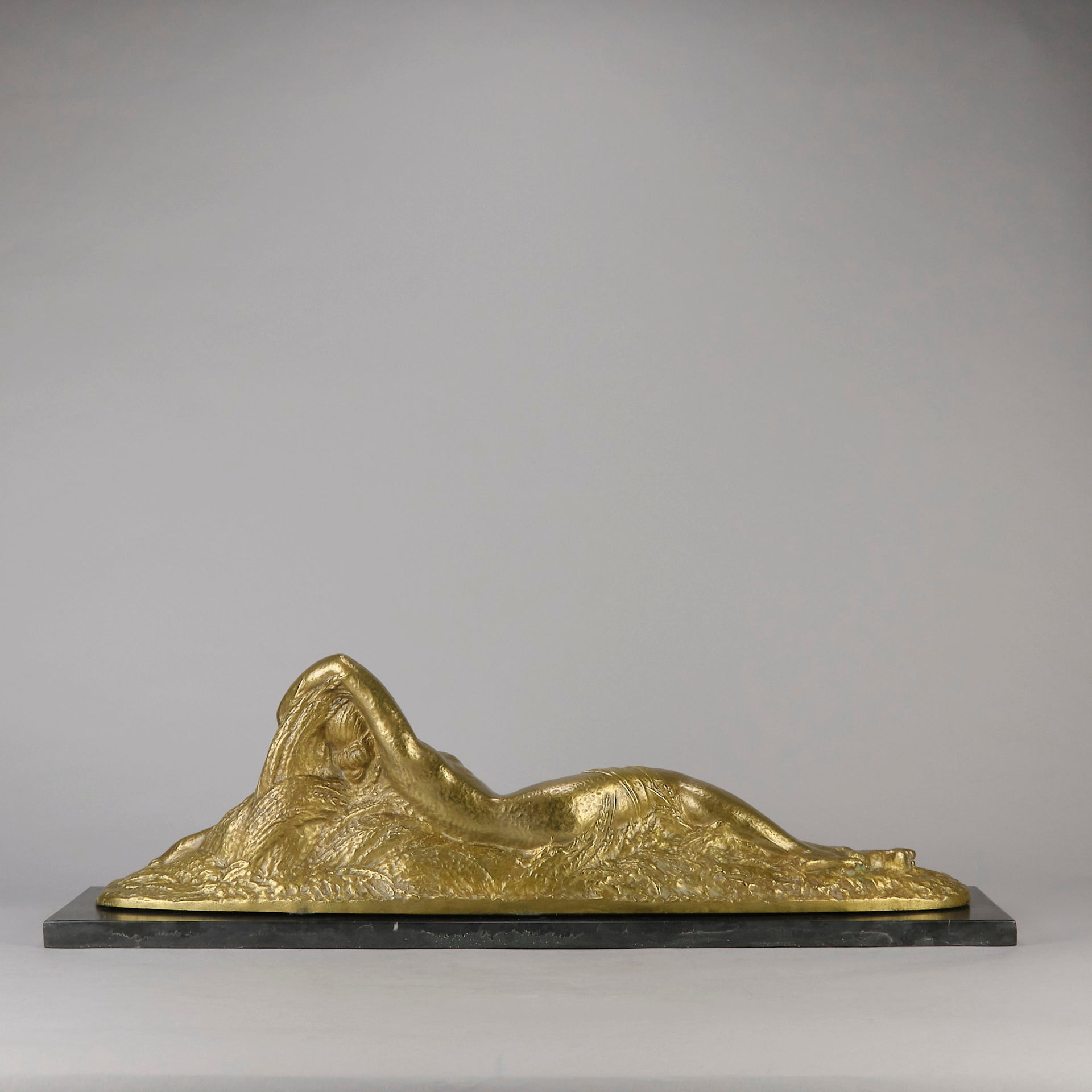 Été by Demetre Chiparus a fabulous Art Deco cold painted gilt and silver bronze figure of a beautiful young woman reclining on a bed of wheat sheaves