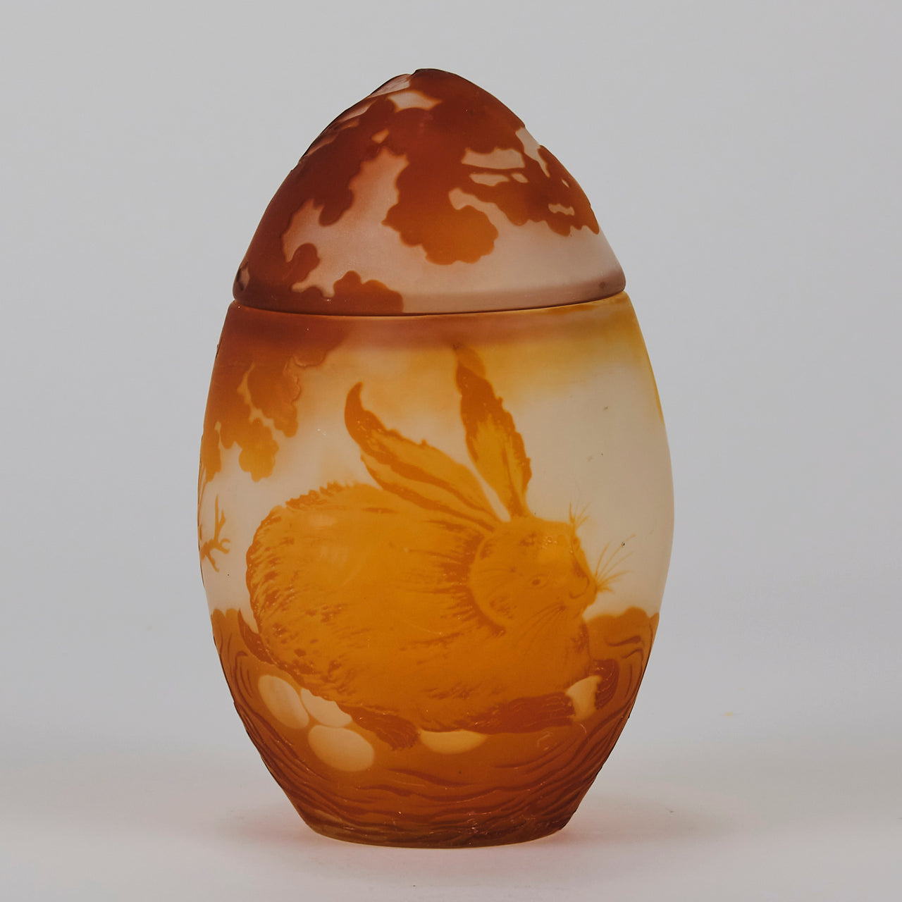 Easter  Egg Vase with Bunny by Émile Gallé. A beautiful and very rare early 20th Century cameo glass lidded egg shaped vase acid cut and etched with an Easter bunny sitting on a nest of eggs under the boughs of some trees in deep orange on a cream/ivory field