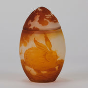 Easter  Egg Vase with Bunny by Émile Gallé. A beautiful and very rare early 20th Century cameo glass lidded egg shaped vase acid cut and etched with an Easter bunny sitting on a nest of eggs under the boughs of some trees in deep orange on a cream/ivory field