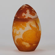Easter  Egg Vase with Bunny by Émile Gallé. A beautiful and very rare early 20th Century cameo glass lidded egg shaped vase acid cut and etched with an Easter bunny sitting on a nest of eggs under the boughs of some trees in deep orange on a cream/ivory field