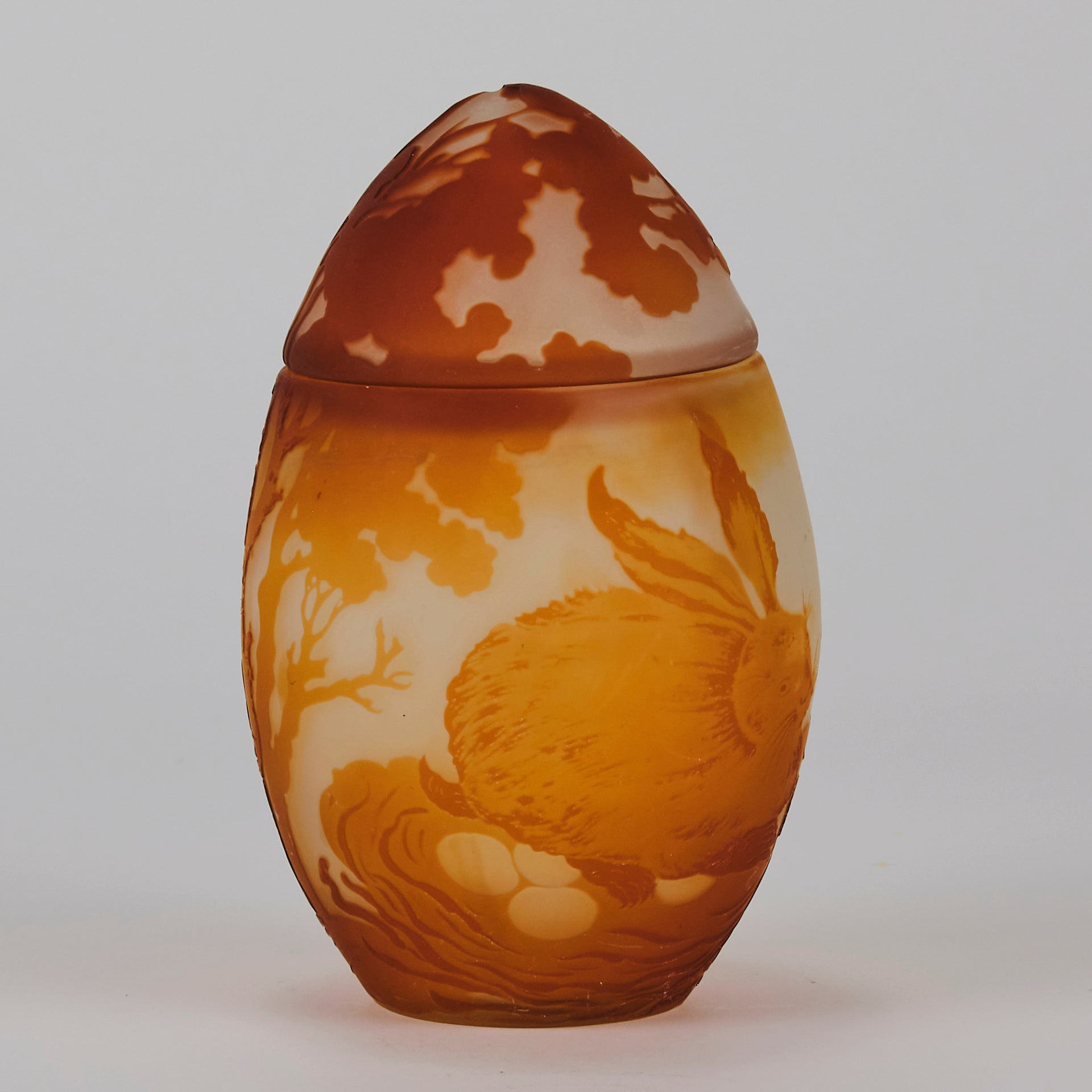 Easter  Egg Vase with Bunny by Émile Gallé. A beautiful and very rare early 20th Century cameo glass lidded egg shaped vase acid cut and etched with an Easter bunny sitting on a nest of eggs under the boughs of some trees in deep orange on a cream/ivory field