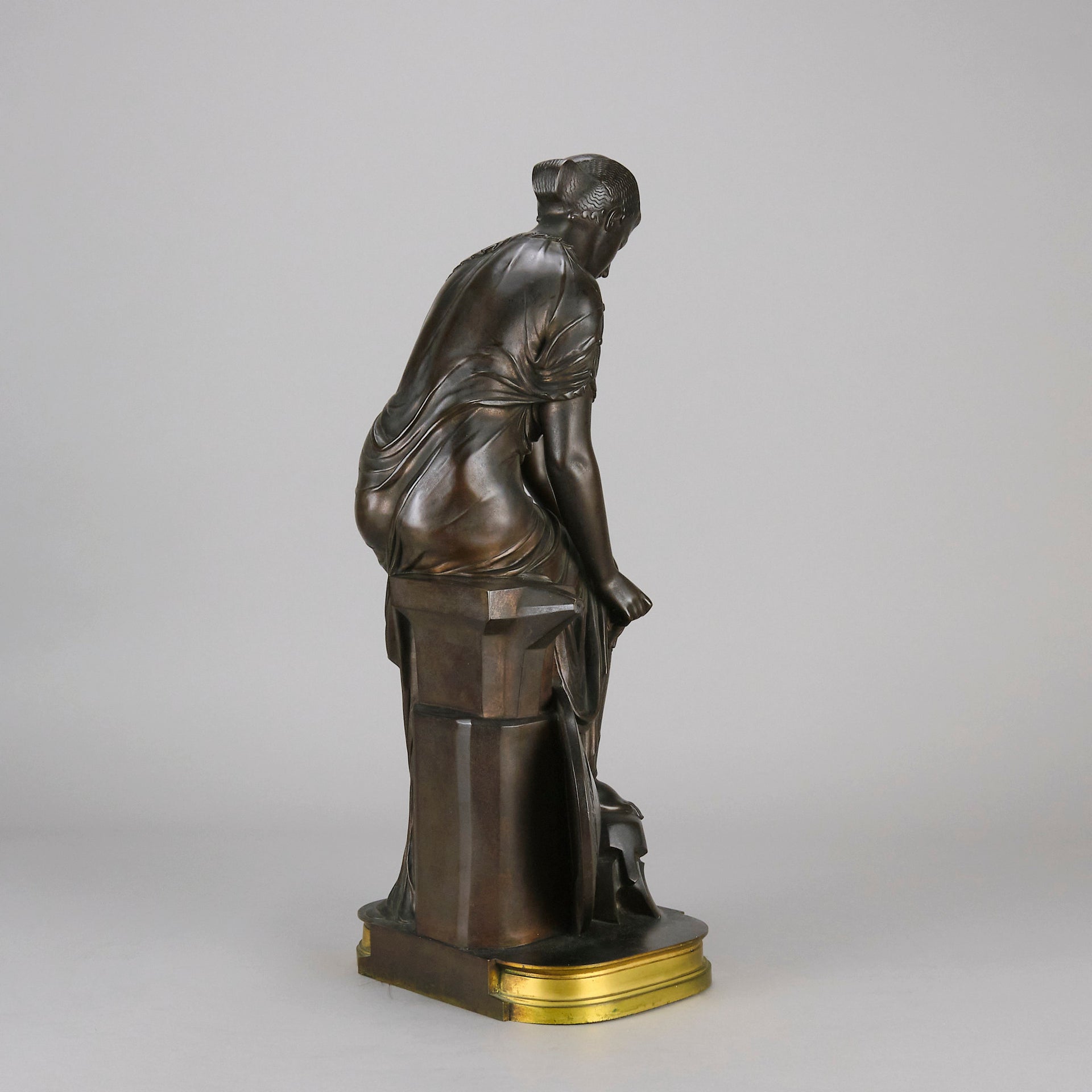 Thetis by Emile Hébert - a French late 19th Century bronze, of a striking female warrior figure known as Thetis the Greek Goddess of War. She is adjusting her shin guards in preparation for her next opponent, whilst sitting on an anvil. Raised on top of a partly gilded base