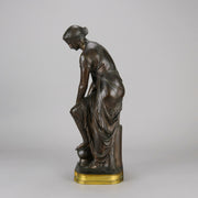 Thetis by Emile Hébert - a French late 19th Century bronze, of a striking female warrior figure known as Thetis the Greek Goddess of War. She is adjusting her shin guards in preparation for her next opponent, whilst sitting on an anvil. Raised on top of a partly gilded base