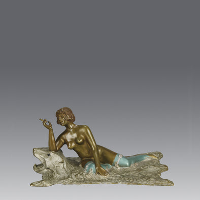 Lady on Bear Skin by Toni Fiedler an attractive early 20th Century bronze study of a lady wearing only a pair of stockings and high heals seductively laying on a bear skin rug whilst smoking a cigarette