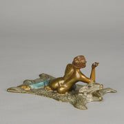 Lady on Bear Skin by Toni Fiedler an attractive early 20th Century bronze study of a lady wearing only a pair of stockings and heals seductively laying on a bear skin rug whilst smoking a cigarette