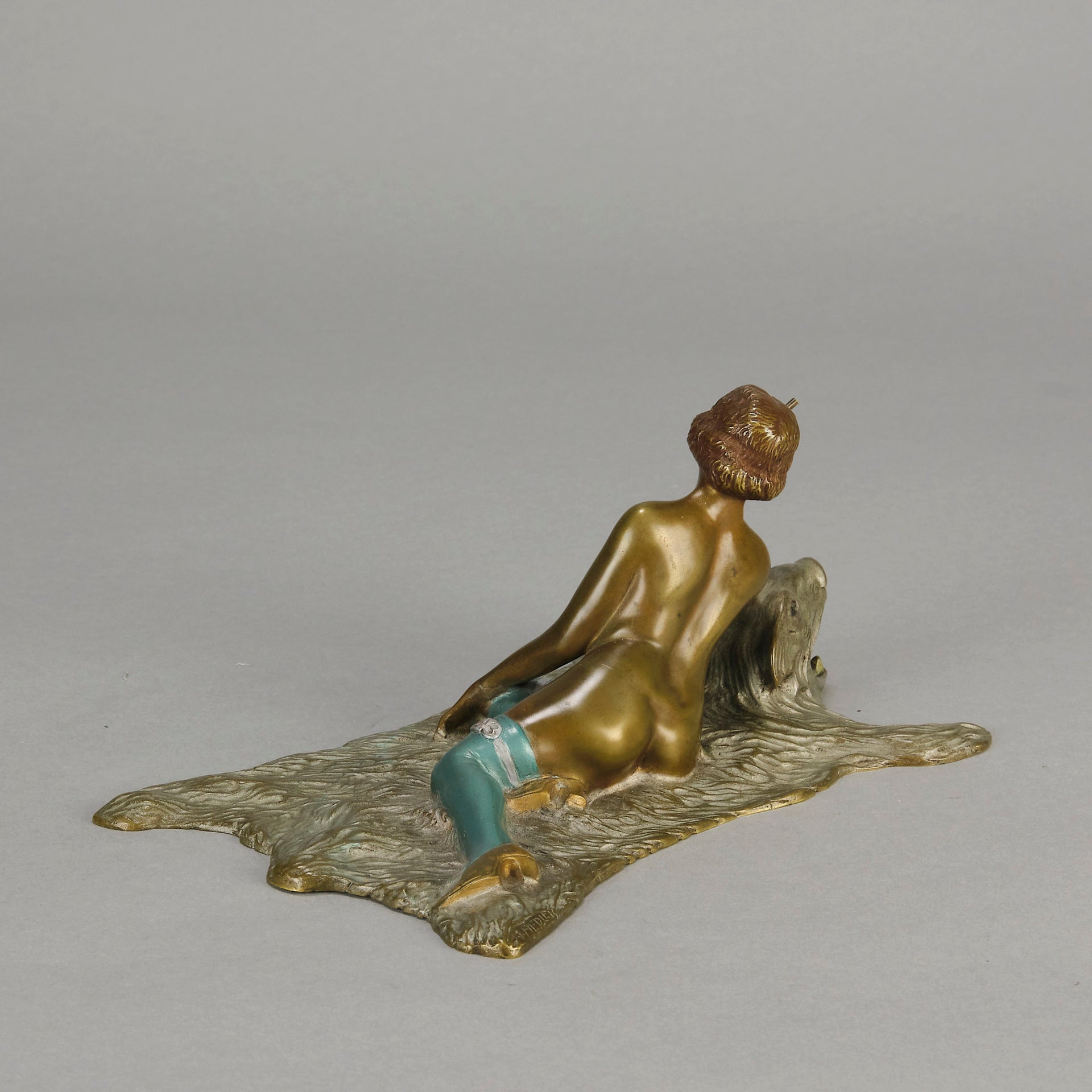 Lady on Bear Skin by Toni Fiedler an attractive early 20th Century bronze study of a lady wearing only a pair of stockings and heals seductively laying on a bear skin rug whilst smoking a cigarette