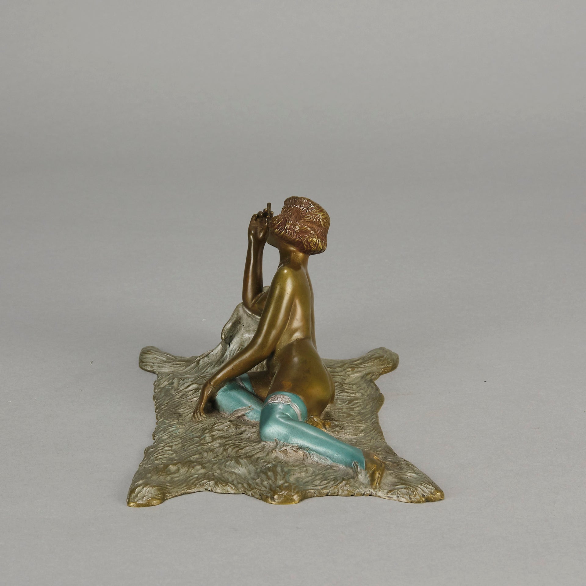 Lady on Bear Skin by Toni Fiedler an attractive early 20th Century bronze study of a lady wearing only a pair of stockings and heals seductively laying on a bear skin rug whilst smoking a cigarette