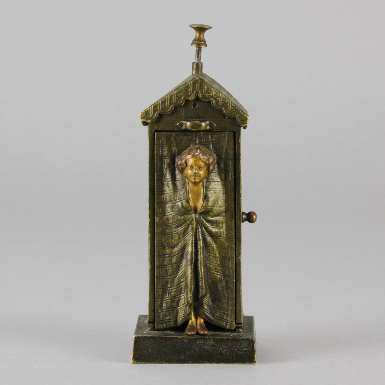 Bathing Belle by Franz Bergman an amusingly erotic early 20th Century Austrian bronze figure of a young beauty in a seaside hut peeking out between the curtains. The mechanism pushes down to turn the front curtain around revealing 'what the butler saw' as her naked body is revealed from behind