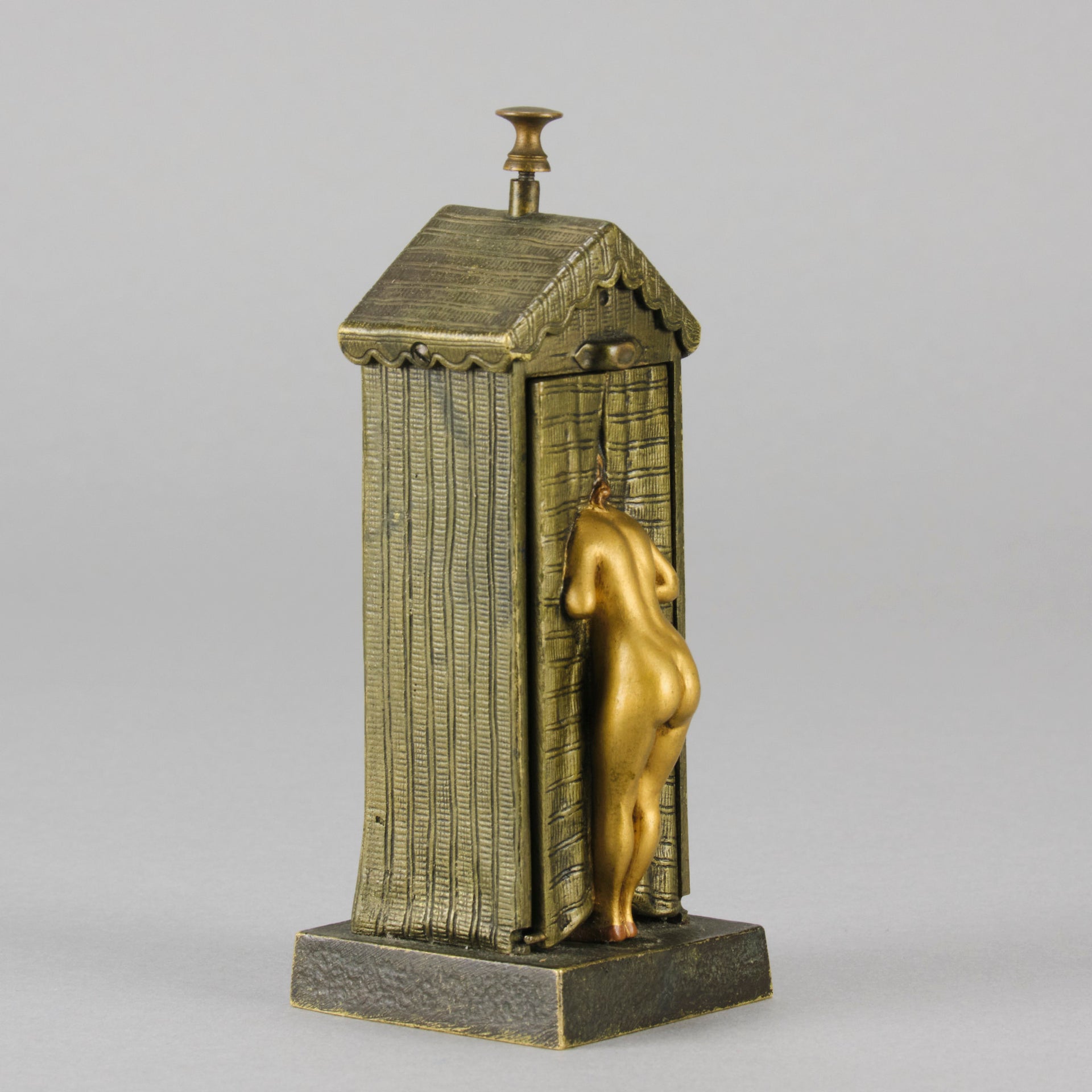 Bathing Belle by Franz Bergman an amusingly erotic early 20th Century Austrian bronze figure of a young beauty in a seaside hut peeking out between the curtains. The mechanism pushes down to turn the front curtain around revealing 'what the butler saw' as her naked body is revealed from behind