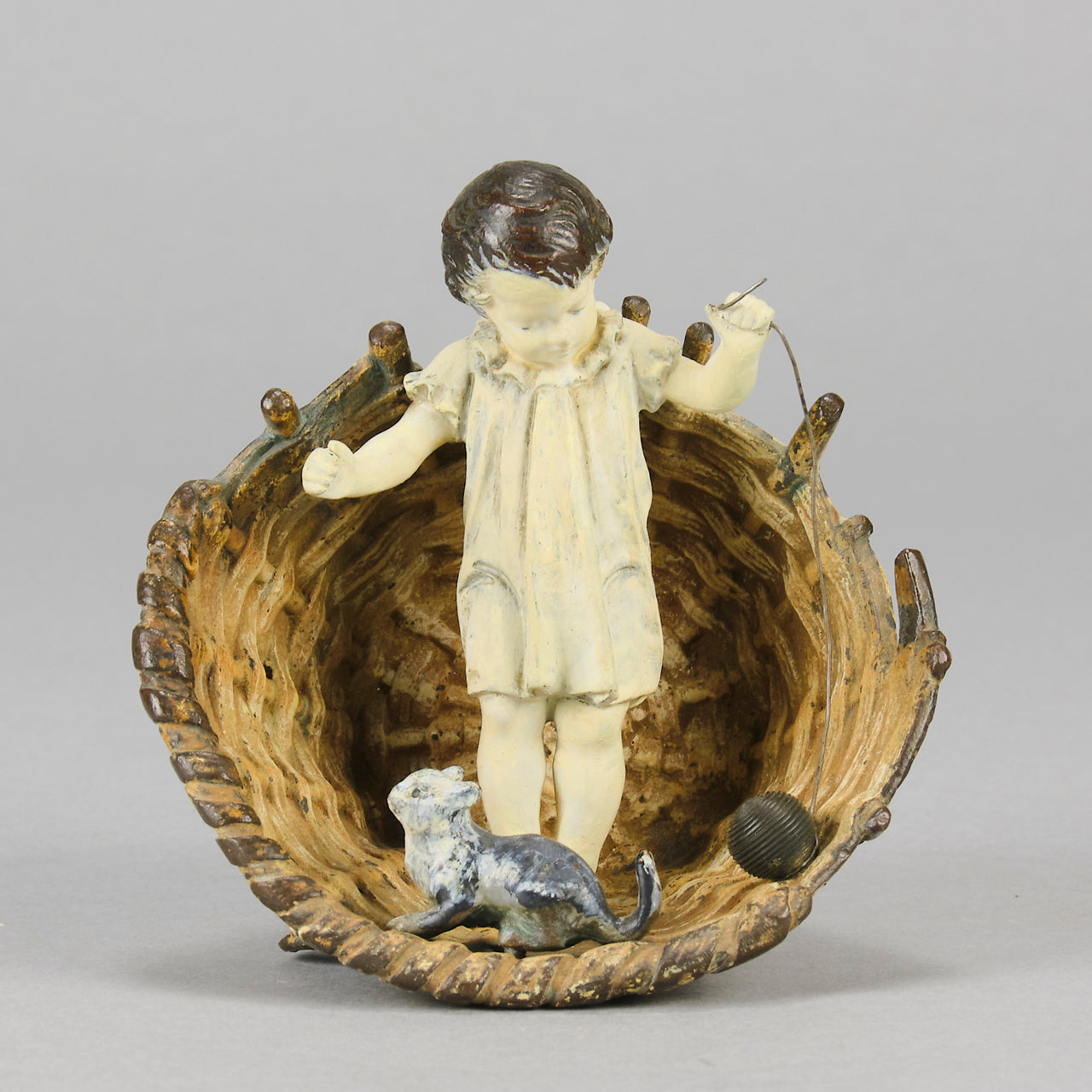 Girl & Cat with Basket - Bergman Bronze - A charming early 20th Century Austrian bronze group study of a young child and cat standing in a wicker basket playing with a ball of string - Hickmet Fine Arts