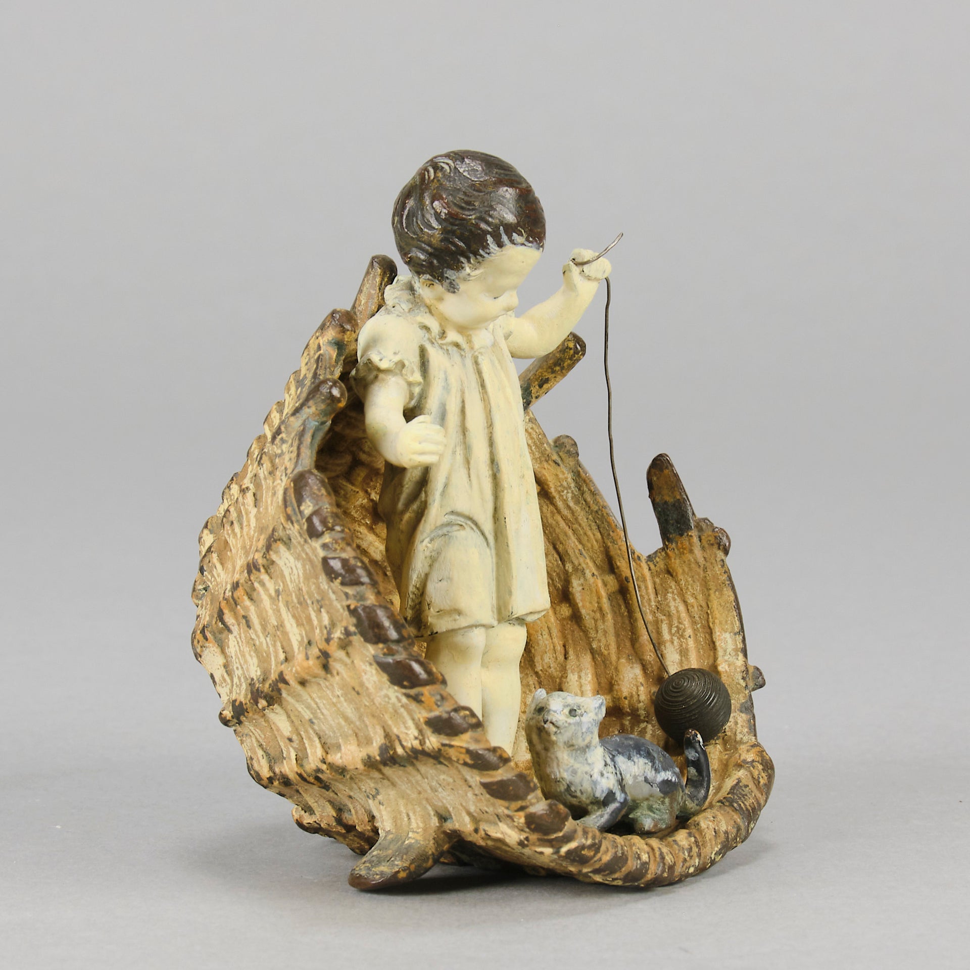 Girl & Cat with Basket - Bergman Bronze - A charming early 20th Century Austrian bronze group study of a young child and cat standing in a wicker basket playing with a ball of string - Hickmet Fine Arts