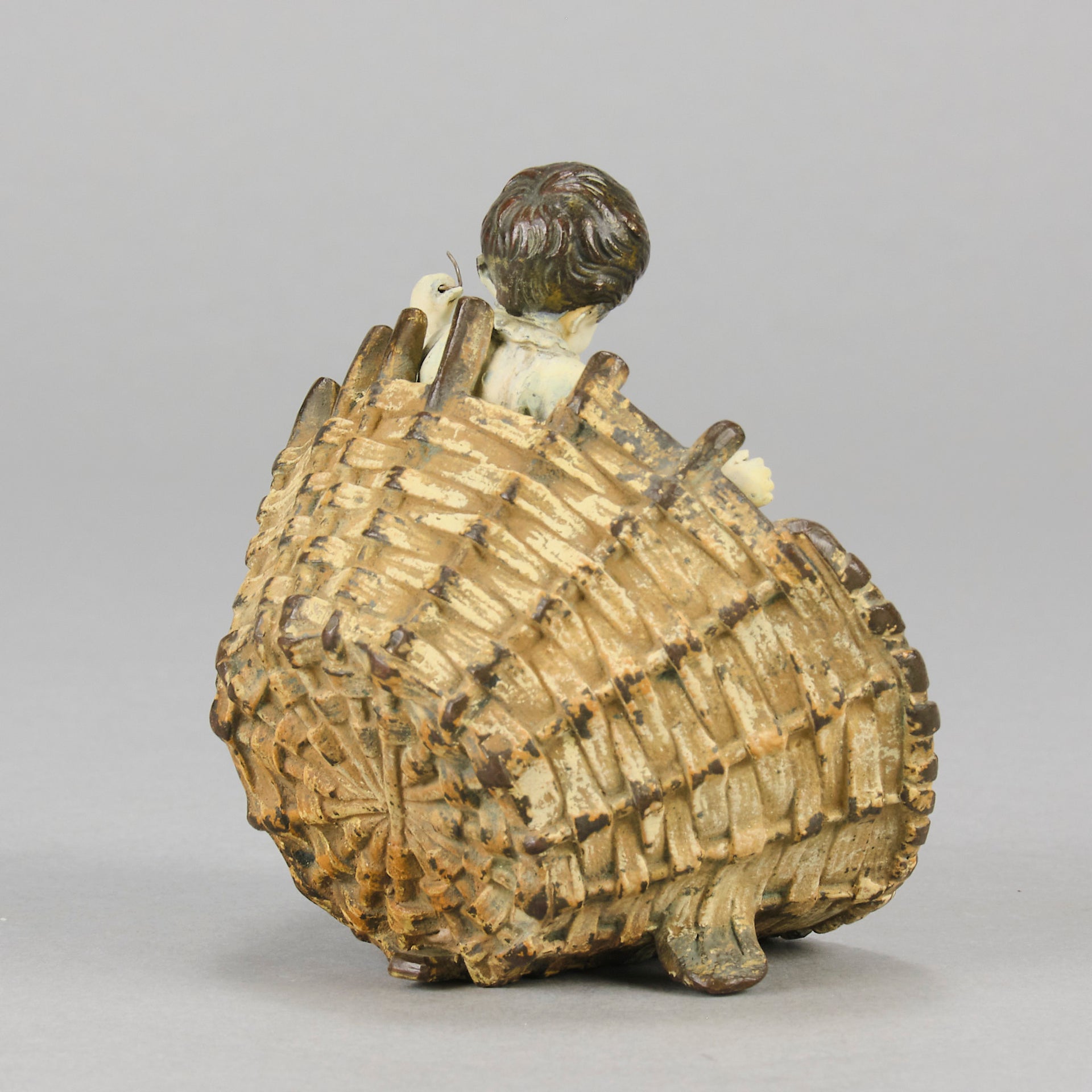 Girl & Cat with Basket - Bergman Bronze - A charming early 20th Century Austrian bronze group study of a young child and cat standing in a wicker basket playing with a ball of string - Hickmet Fine Arts