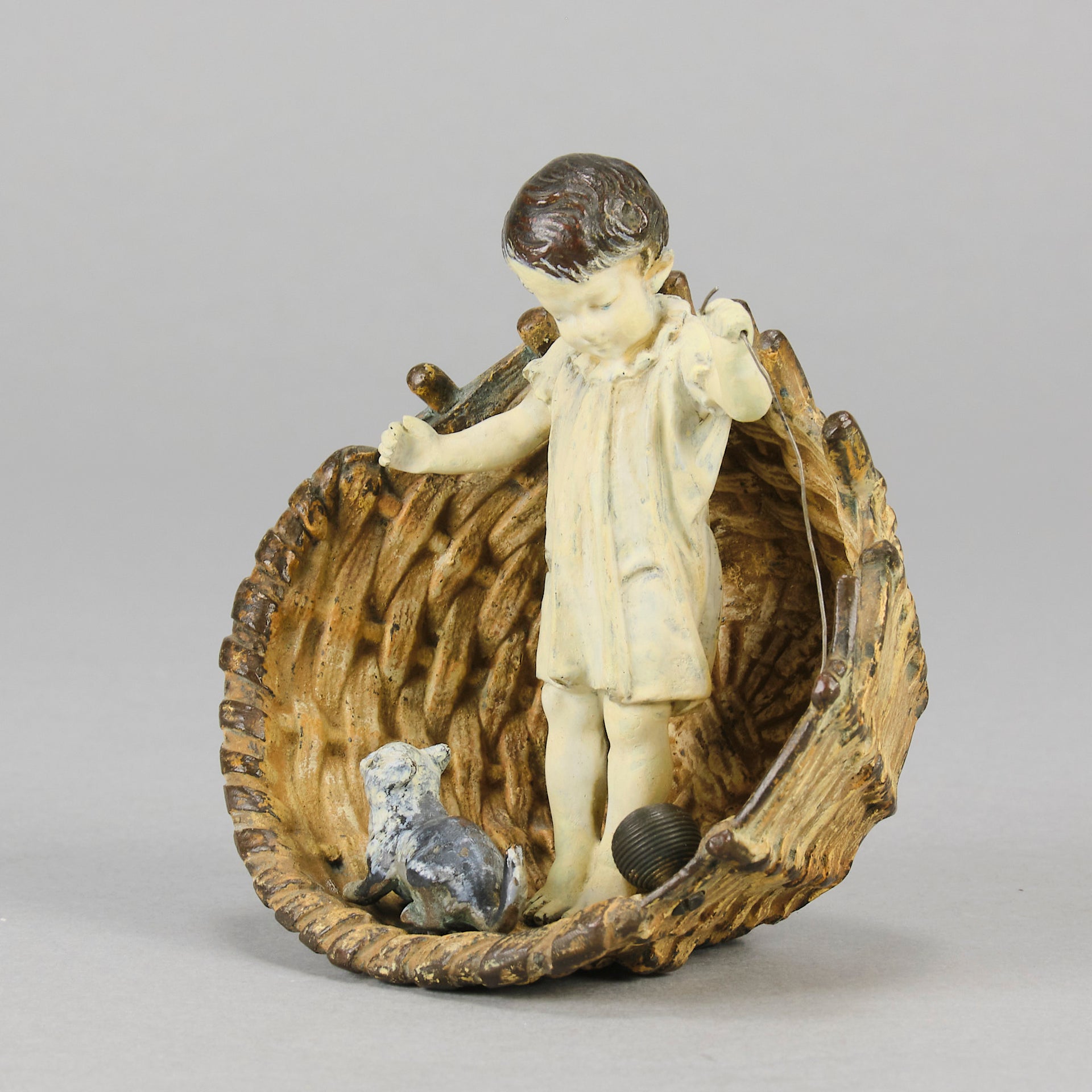 Girl & Cat with Basket - Bergman Bronze - A charming early 20th Century Austrian bronze group study of a young child and cat standing in a wicker basket playing with a ball of string - Hickmet Fine Arts