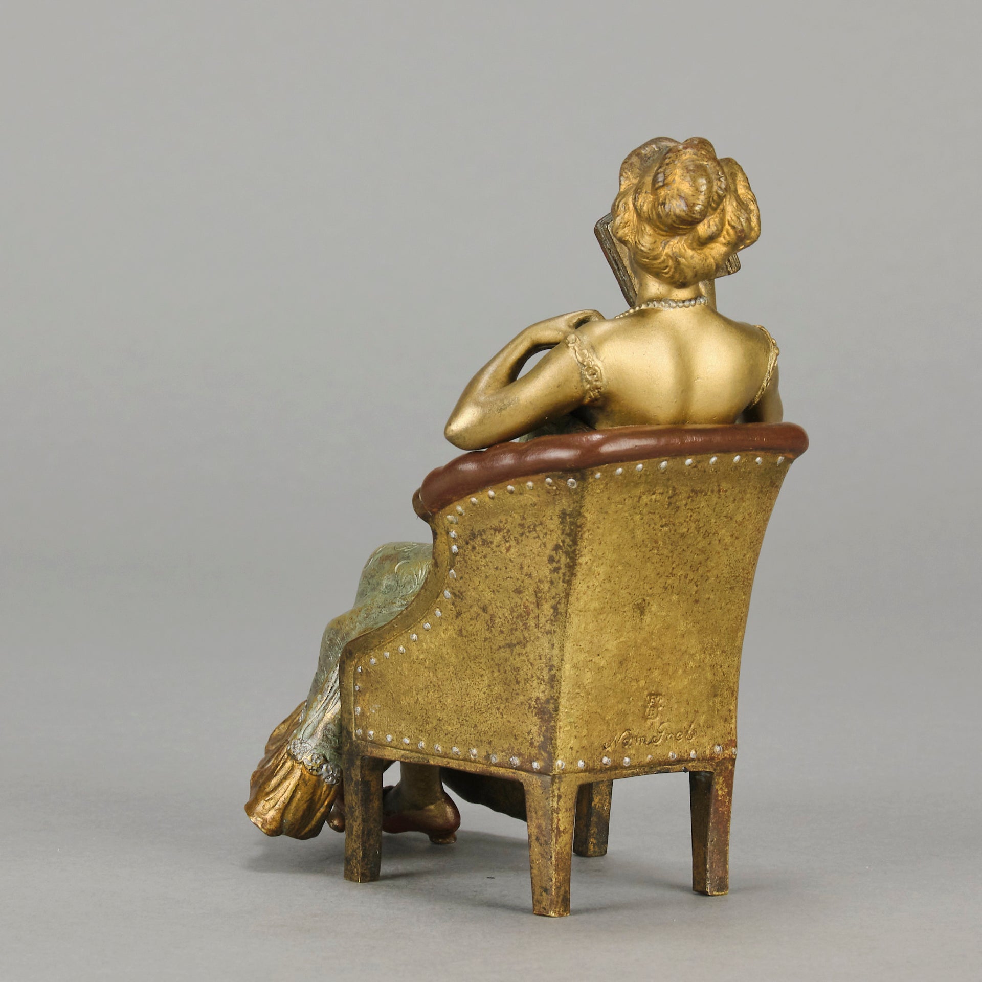 Lady Reading by Franz Bergman an attractive early 20th Century Austrian bronze study of a seated lady wearing a loosley fitted night dress reading a book, her dress lifting to reveal her beautiful body