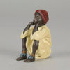 Seated Boy by Franz Bergman an early 20th Century cold painted Austrian bronze figure of a young Arab boy dressed in full period orientalist attire seated with his head resting upon his hands in deep thought