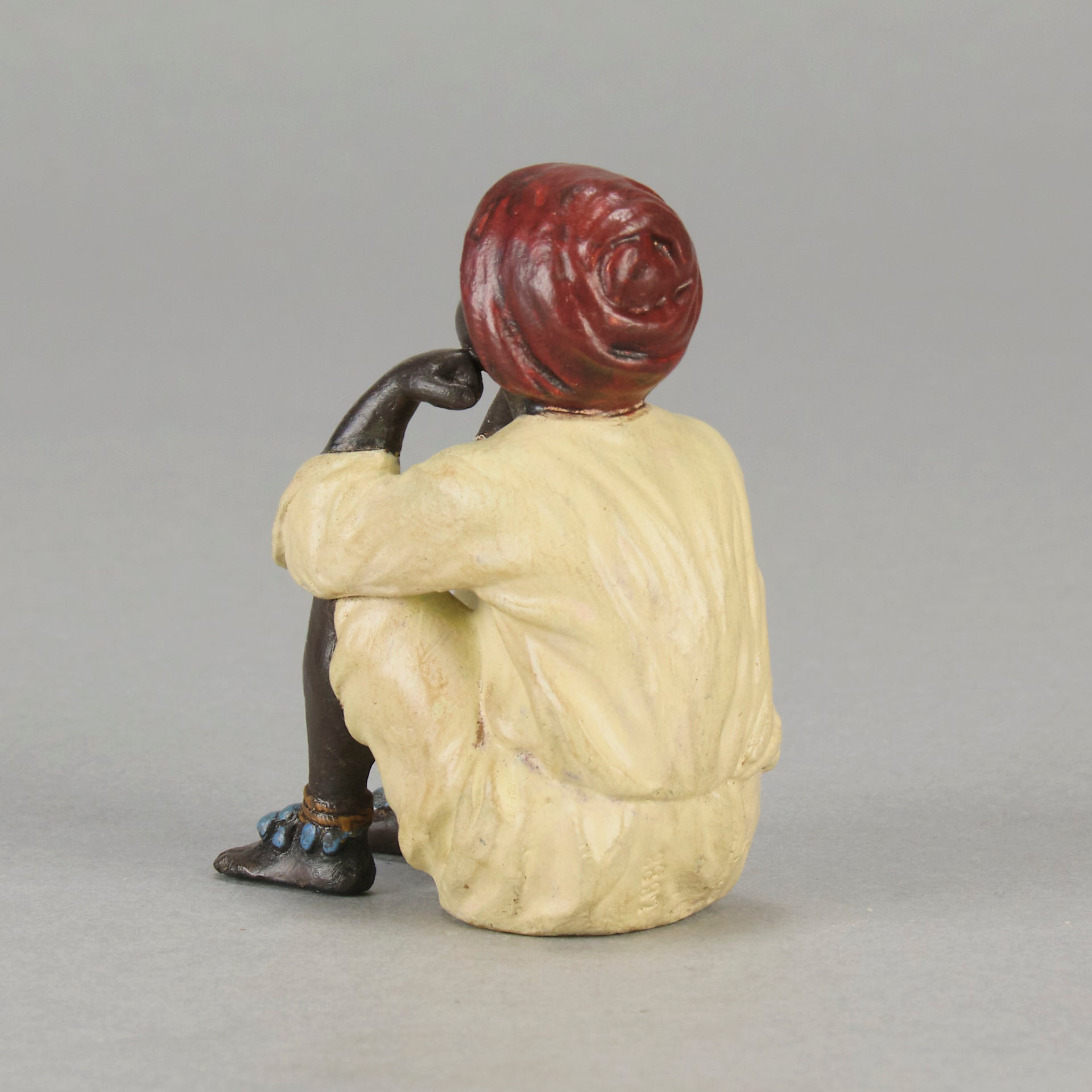 Seated Boy by Franz Bergman an early 20th Century cold painted Austrian bronze figure of a young Arab boy dressed in full period orientalist attire seated with his head resting upon his hands in deep thought