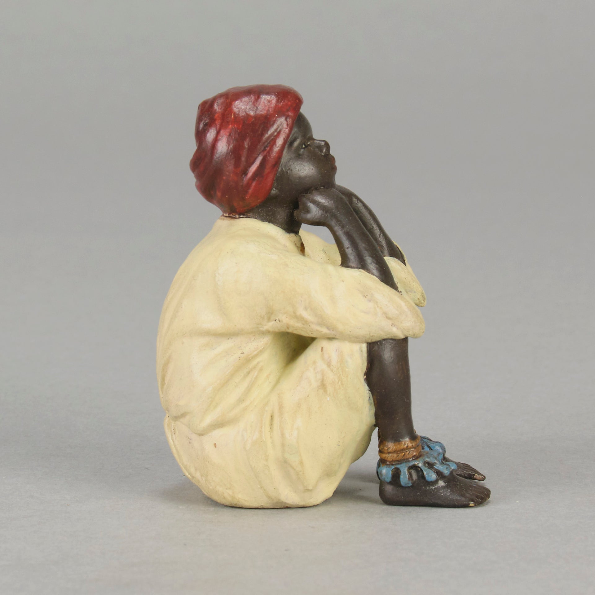 Seated Boy by Franz Bergman an early 20th Century cold painted Austrian bronze figure of a young Arab boy dressed in full period orientalist attire seated with his head resting upon his hands in deep thought