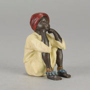 Seated Boy by Franz Bergman an early 20th Century cold painted Austrian bronze figure of a young Arab boy dressed in full period orientalist attire seated with his head resting upon his hands in deep thought