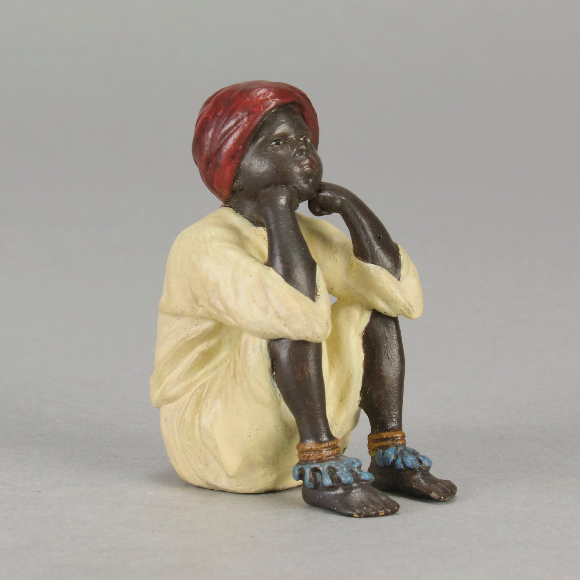 Seated Boy by Franz Bergman an early 20th Century cold painted Austrian bronze figure of a young Arab boy dressed in full period orientalist attire seated with his head resting upon his hands in deep thought