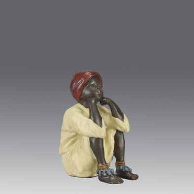 Seated Boy by Franz Bergman an early 20th Century cold painted Austrian bronze figure of a young Arab boy dressed in full period orientalist attire seated with his head resting upon his hands in deep thought